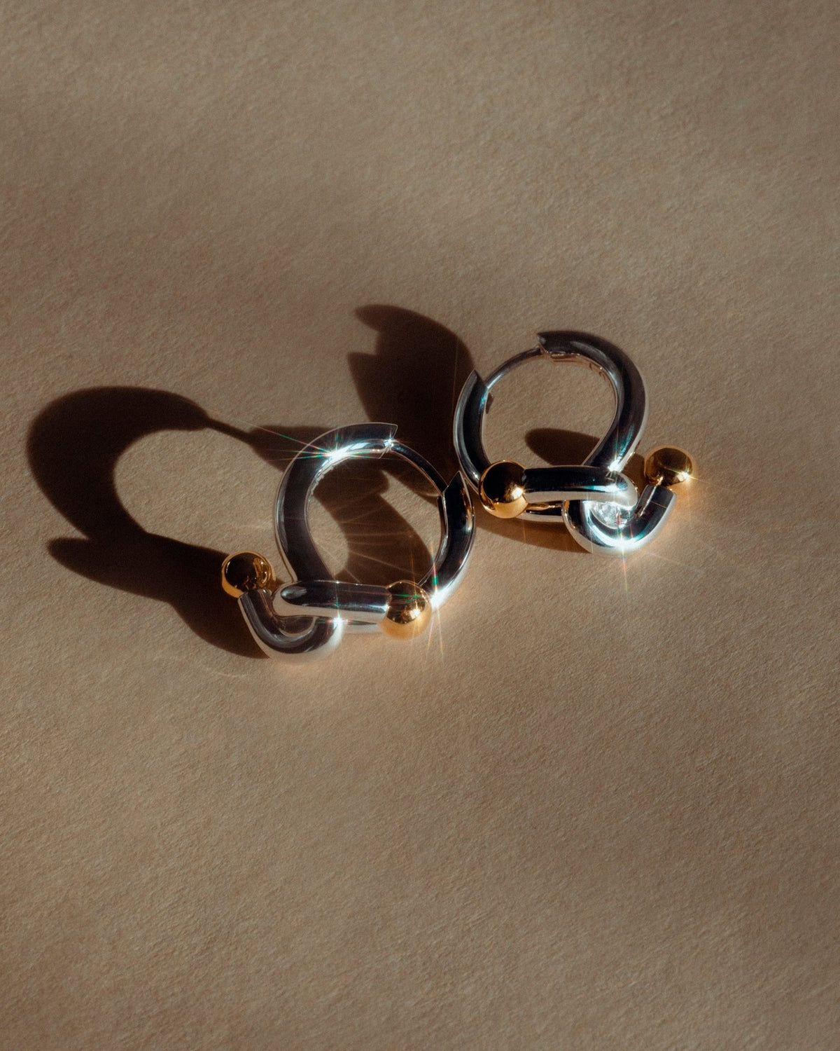 Falcat earrings in 925 silver, shown on the ear.