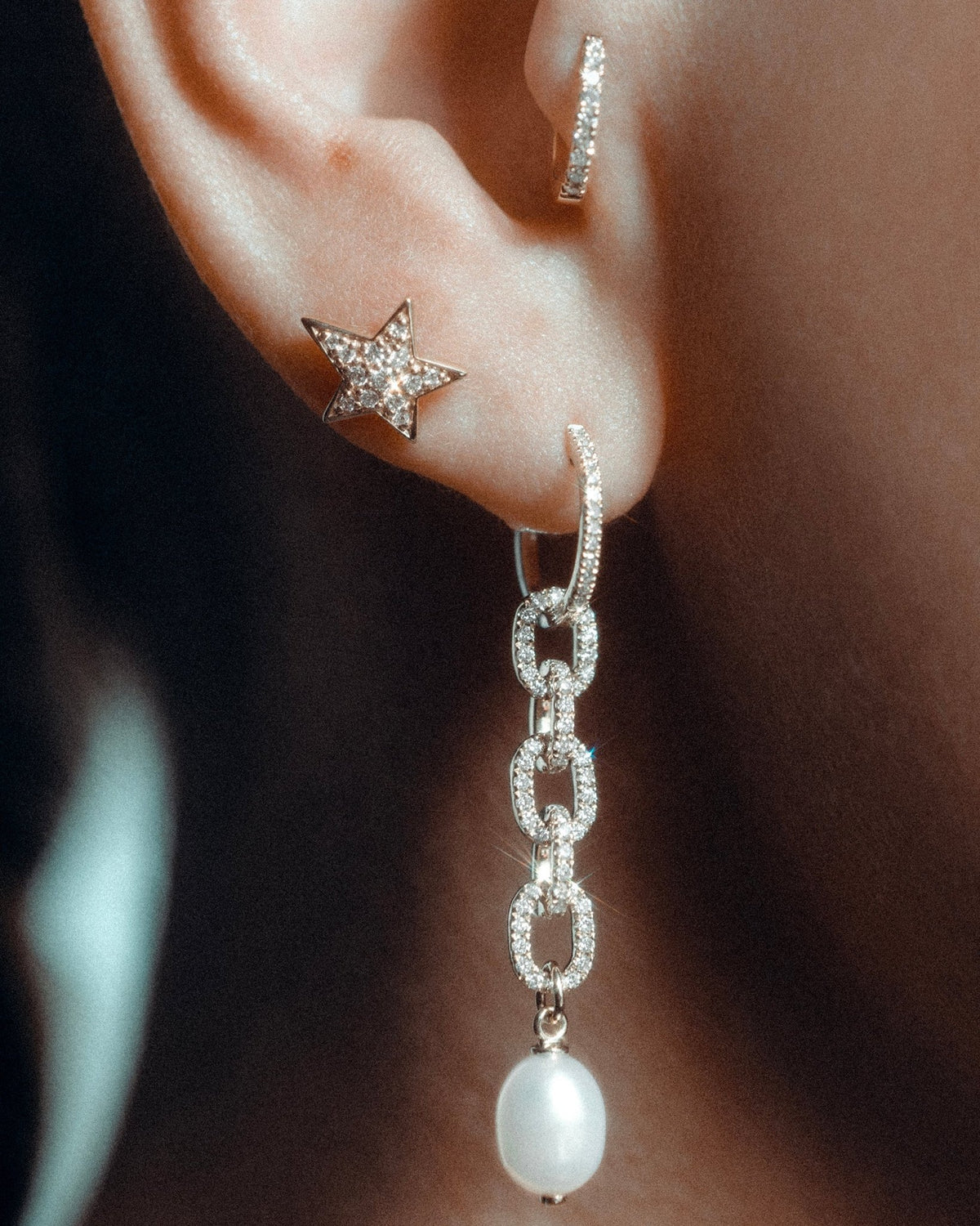 Celeste star in 14k yellow gold, set with a natural diamond, shown on the ear.