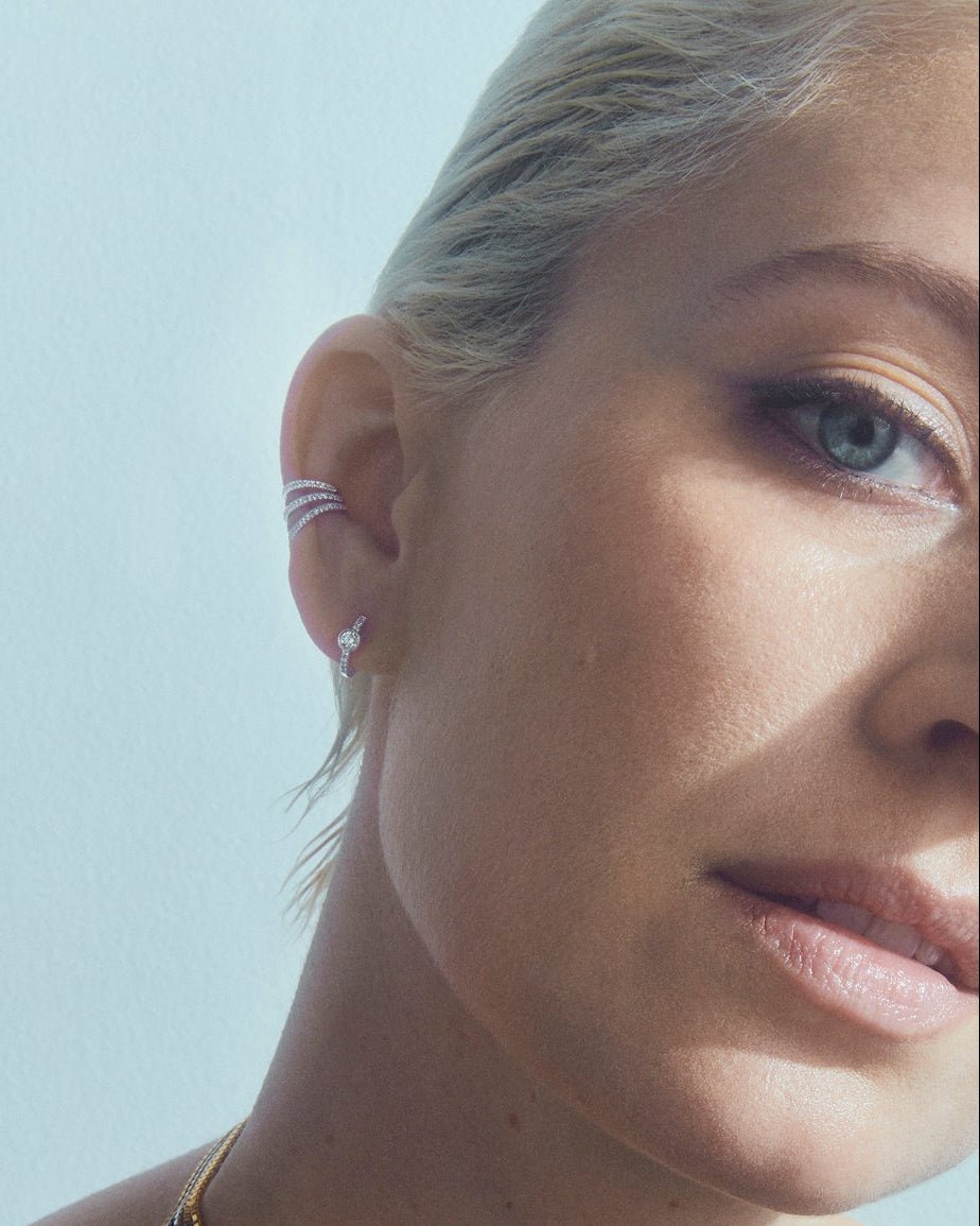Dot diamond hoop 11mm in 14k white gold, set with a natural diamond, shown on the ear.