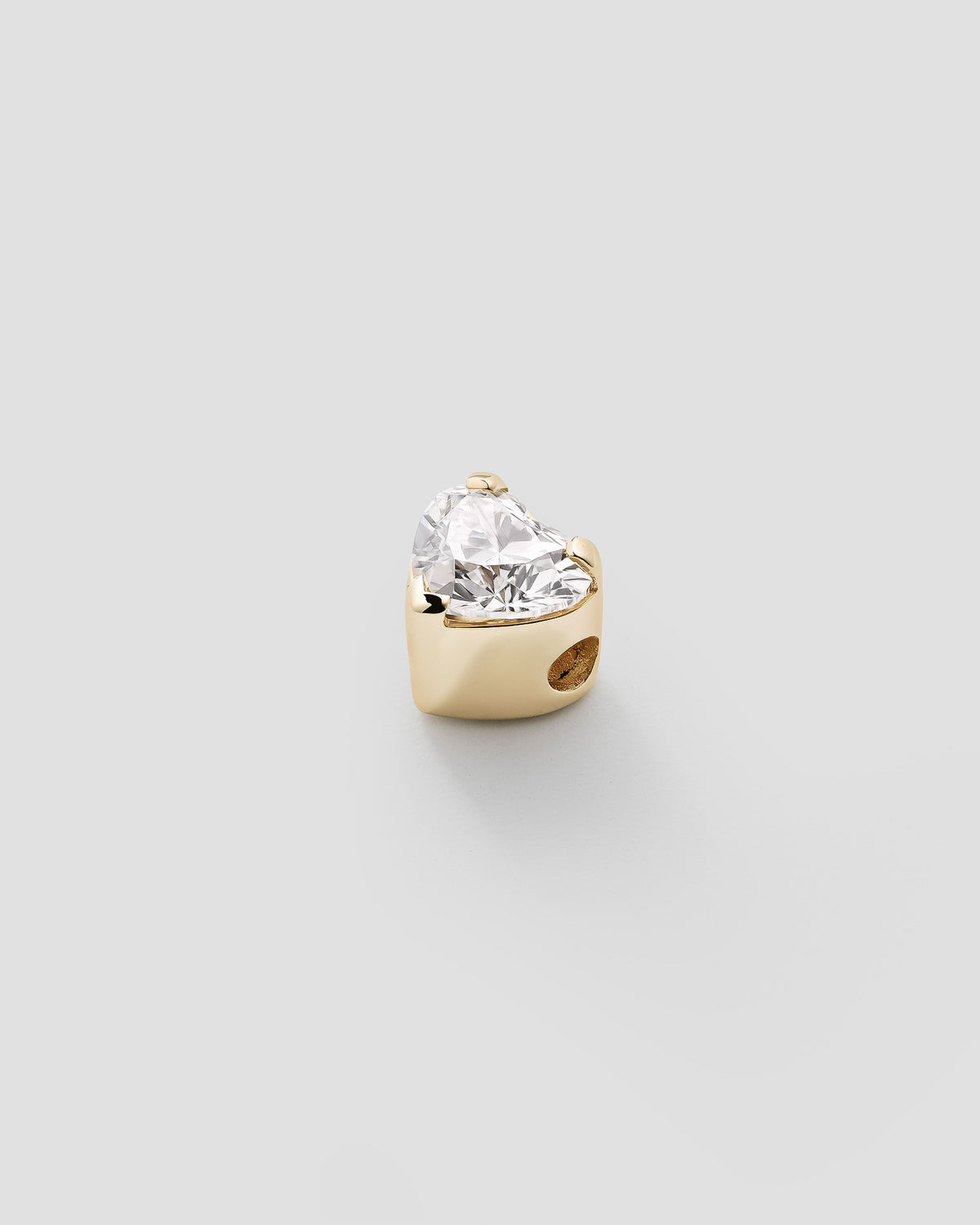 Erosia heart charm in 14k yellow gold, set with a lab grown diamond, detail view.