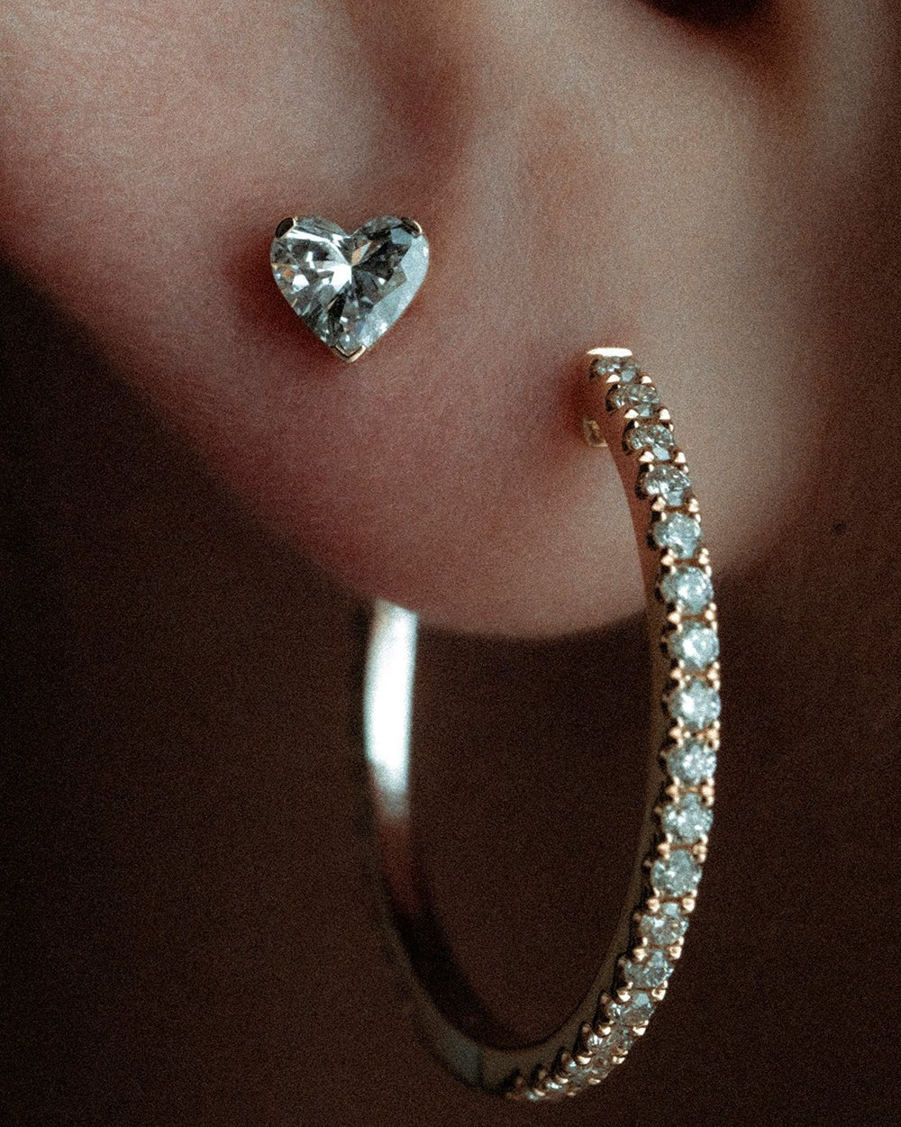 Erosia heart in 14k yellow gold, set with a natural diamond, shown on the ear.